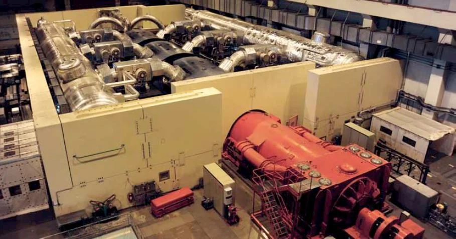 Turbozespół EJ Leibstadt. Na pierwszym planie widoczny czerwony generator, dalej trzy granatowe turbiny niskiego ciśnienia. Ściany dookoła zabezpieczają przed promieniowaniem.
