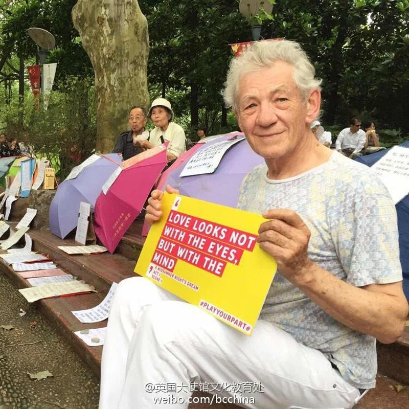 Sir Ian McKellen trzyma tabliczkę z szekspirowskim cytatem.