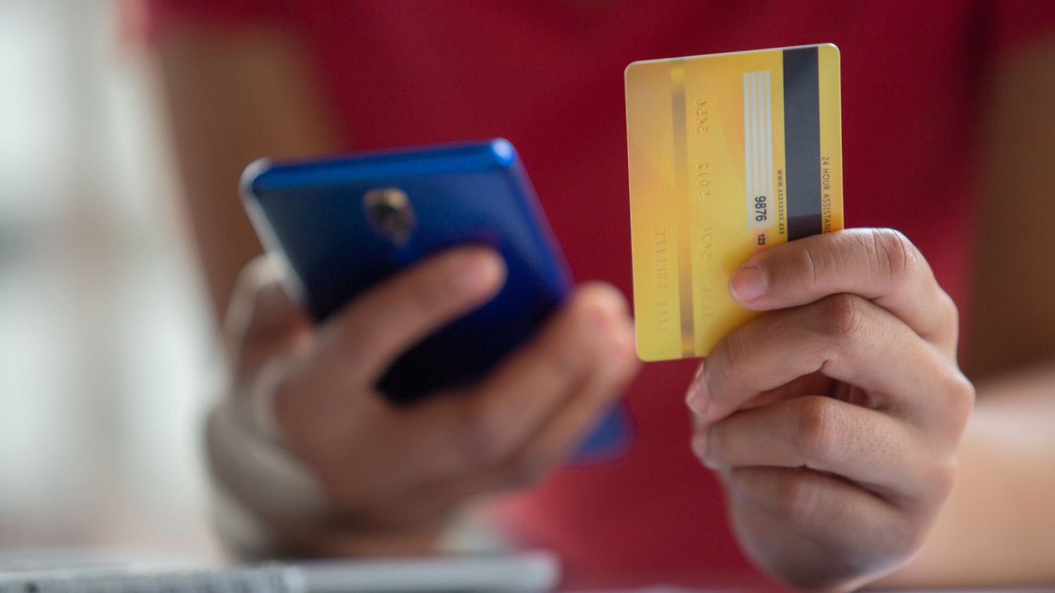 Pilnuj przelewów w Wielkanoc. Jeden błąd i pieniądze utkną na kilka dni Osoba trzymająca w dłoniach kartę bankową i smartfon.