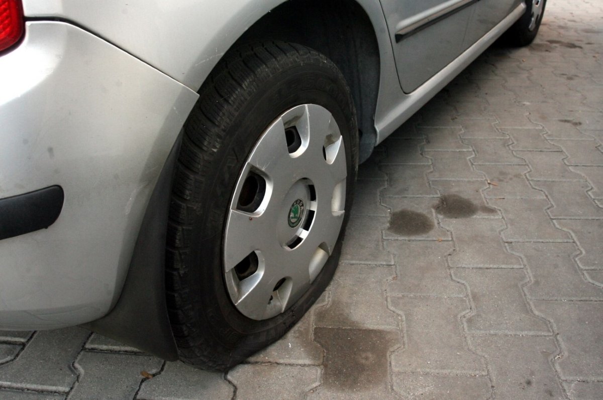 Samochód z przebitą oponą. Zdjęcie ilustracyjne.