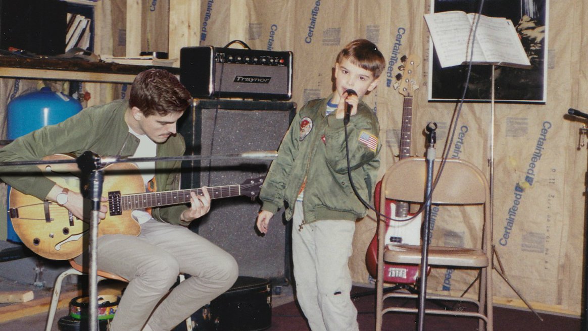 20-latek towarzyszący na scenie swojej młodszej wersji.