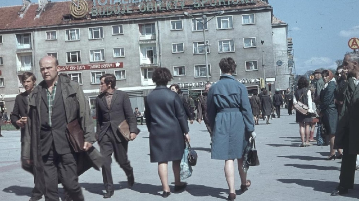 Widoczna kamienica z neonem "Totalizator Sportowy buduje obiekty sportowe" i dekoracjami, 1969 r.