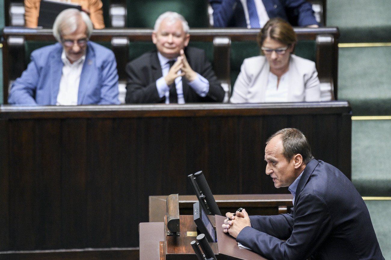 Poseł Paweł Kukiz na trybunie sejmowej. W tle Jarosław Kaczyński, prezes PiS )na środku).