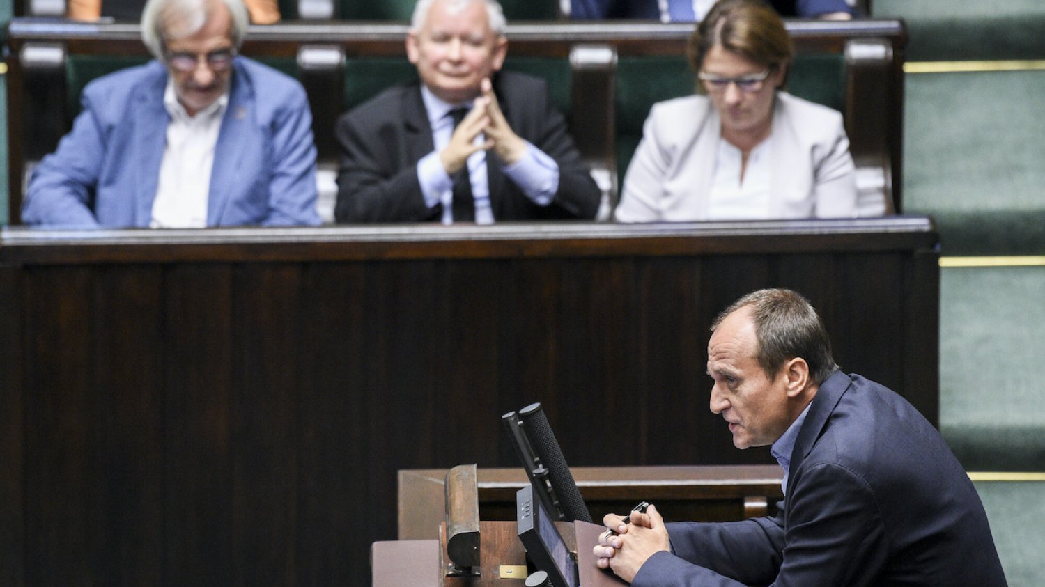 Poseł Paweł Kukiz na trybunie sejmowej. W tle Jarosław Kaczyński, prezes PiS )na środku).