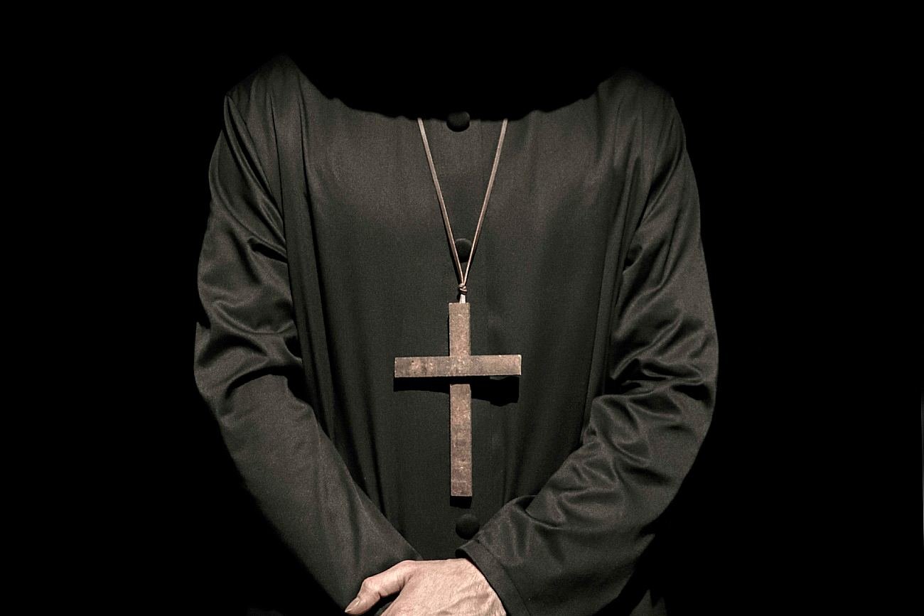 Ksiądz egzorcysta na czarnym, mrocznym tle.