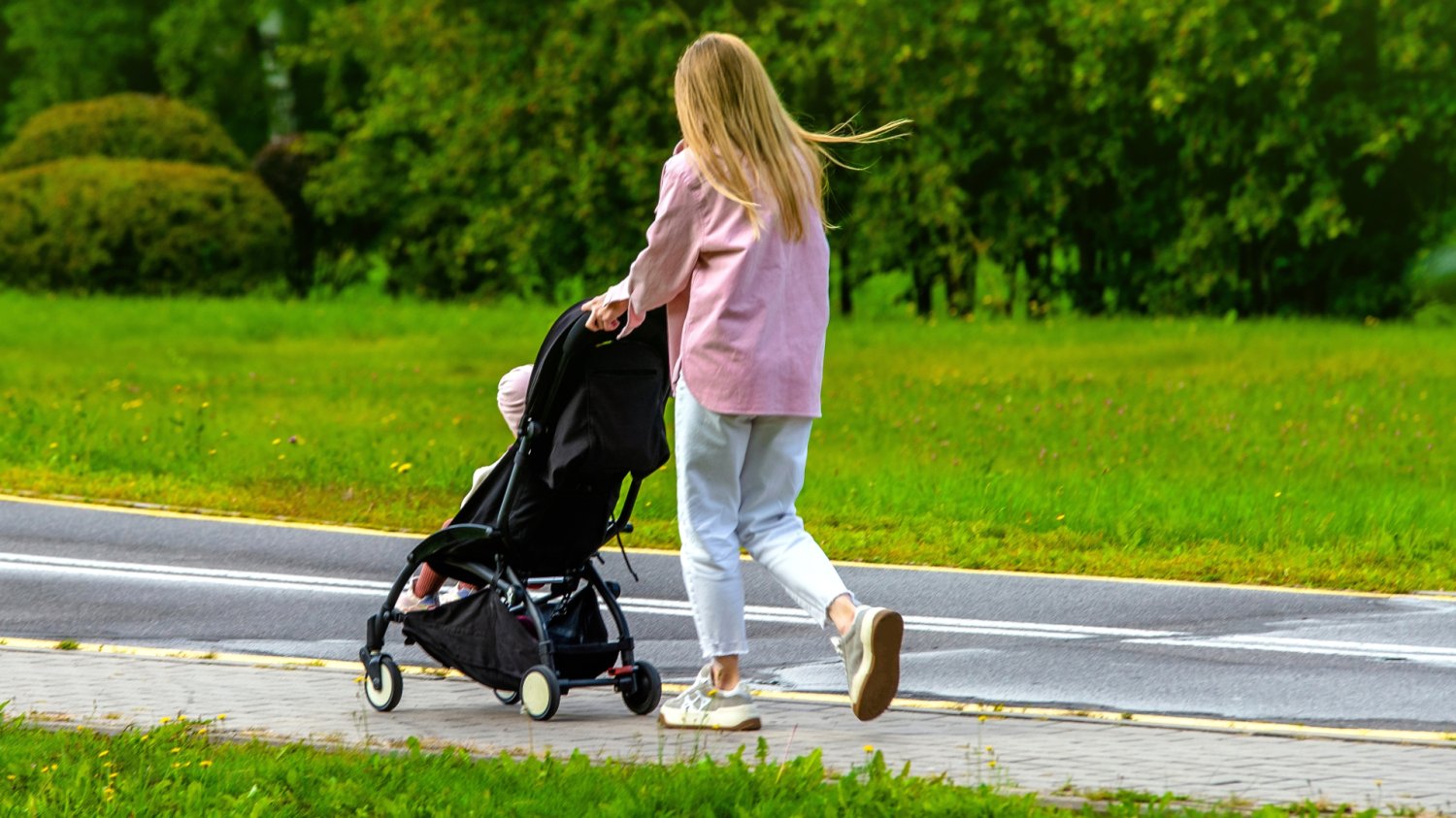 Samotna matka z wózkiem z dzieckiem, co ilustruje temat opieki naprzemiennej i podziału świadczenia 800 plus z ZUS.