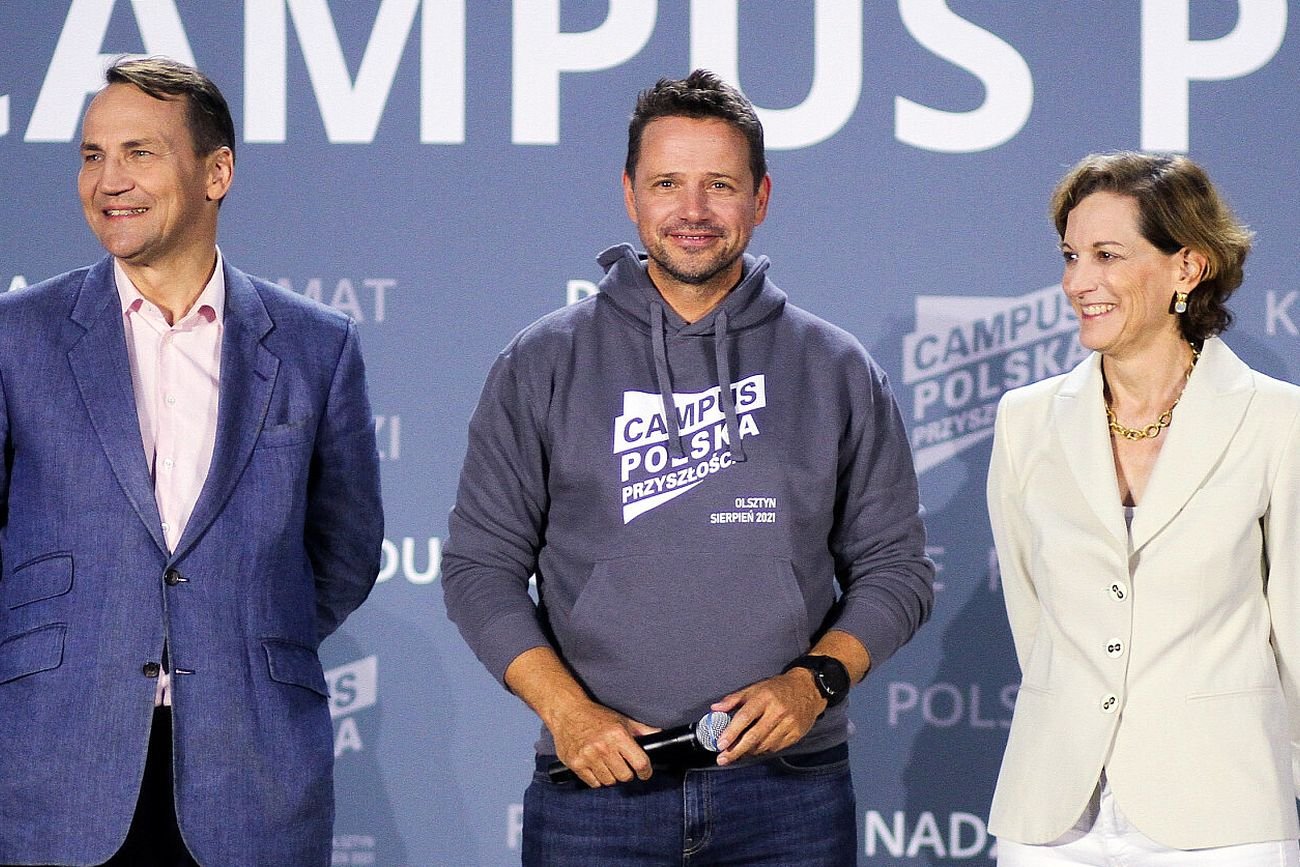 Radosław Sikorski (z lewej) dziękuje Rafałowi Trzaskowskiemu (w środku) za wsparcie w sprawie dziwnych pytań o jego żonę Anne Aplebaum (z prawej)