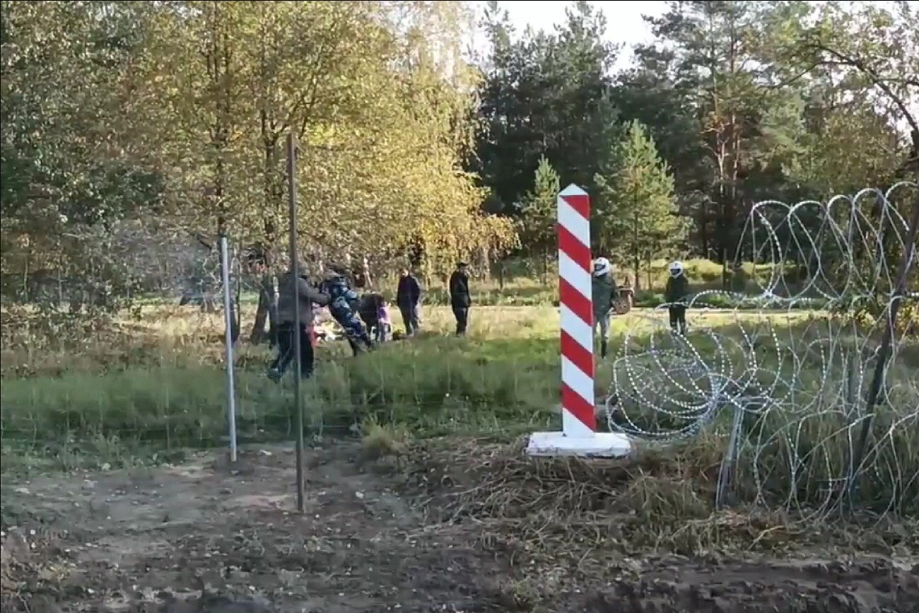 MON pokazało na Twitterze krótki film, na którym "widać jak migrant wraz z dzieckiem pozuje do zdjęcia wykonując polecenia białoruskiego żołnierza".