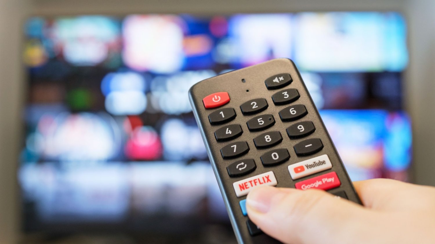 Koniec abonamentu RTV to nie powód do radości. Nowa opłata obejmie prawie każdego Osoba trzymająca pilot w dłoni, w tle telewizor.