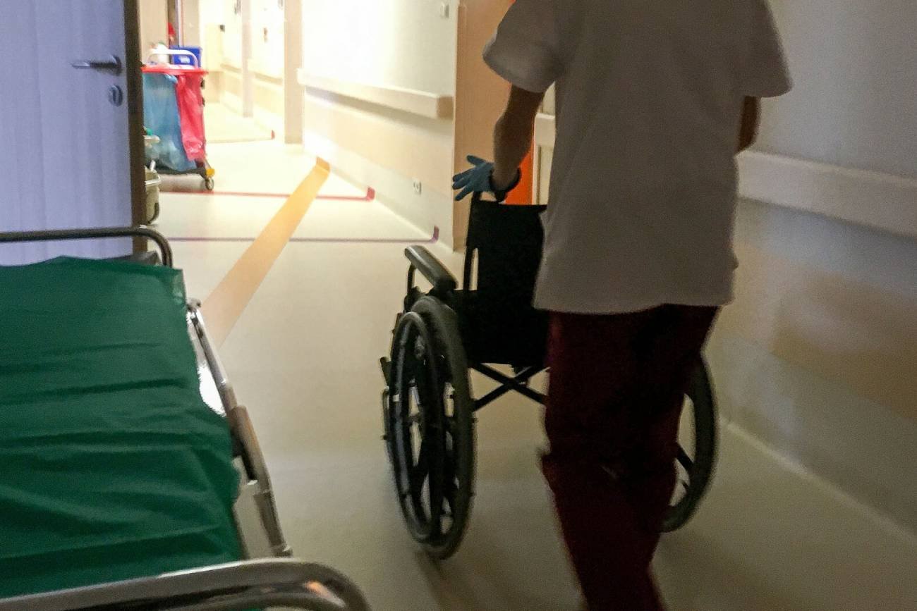 pracownik medyczny prowadzi wózek inwalidzki