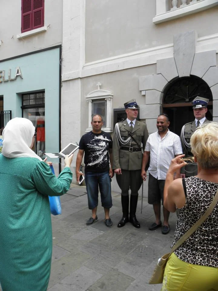 Muzułmanie robiący sobie zdjęcia z polskimi żołnierzami wychodzącymi z Katedry przy Main Street.