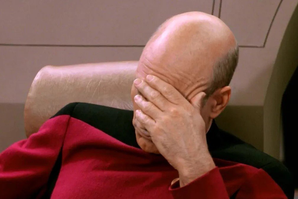 Kapitan Picard trzymający rękę na czole.