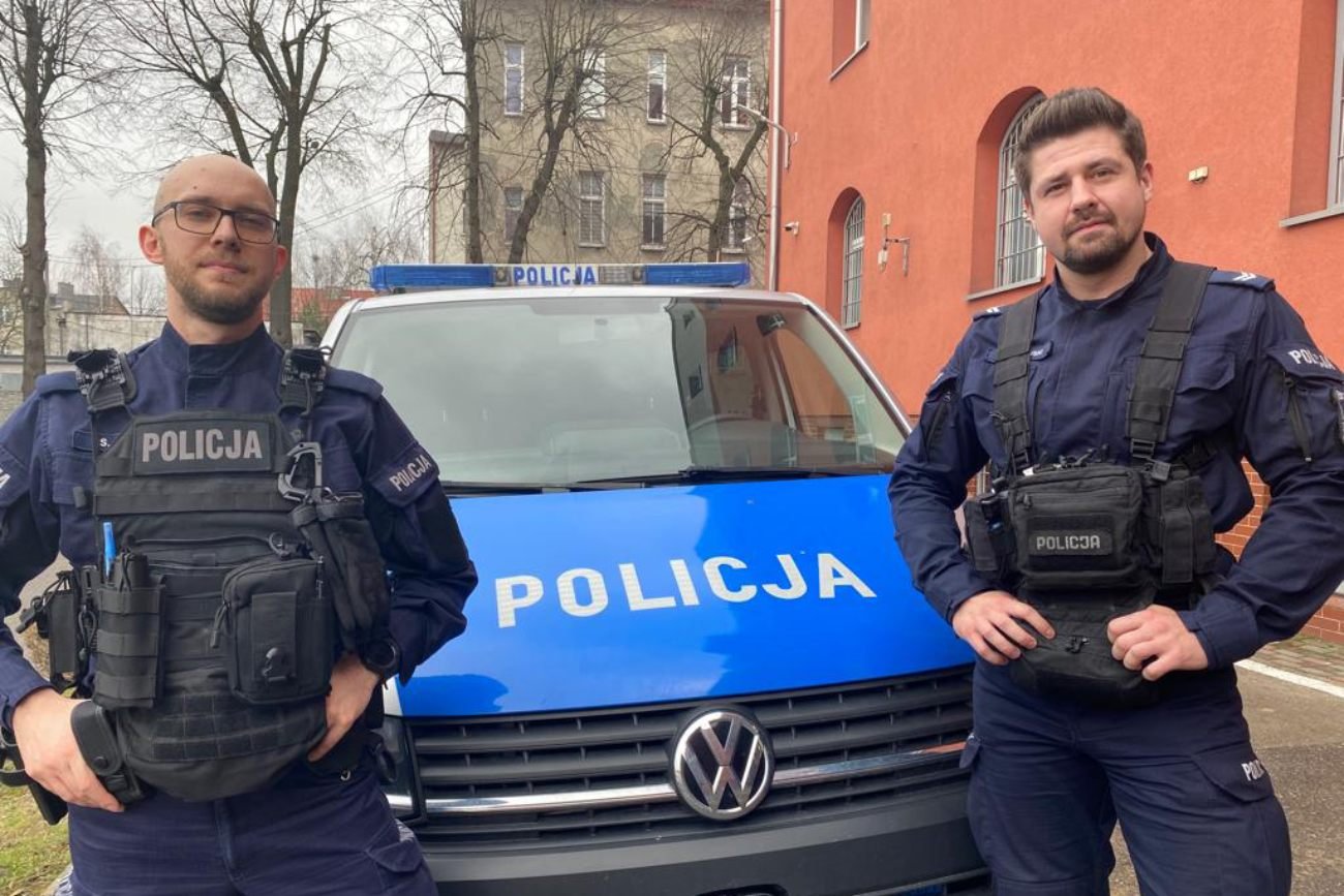 Dwaj policjanci przed radiowozem