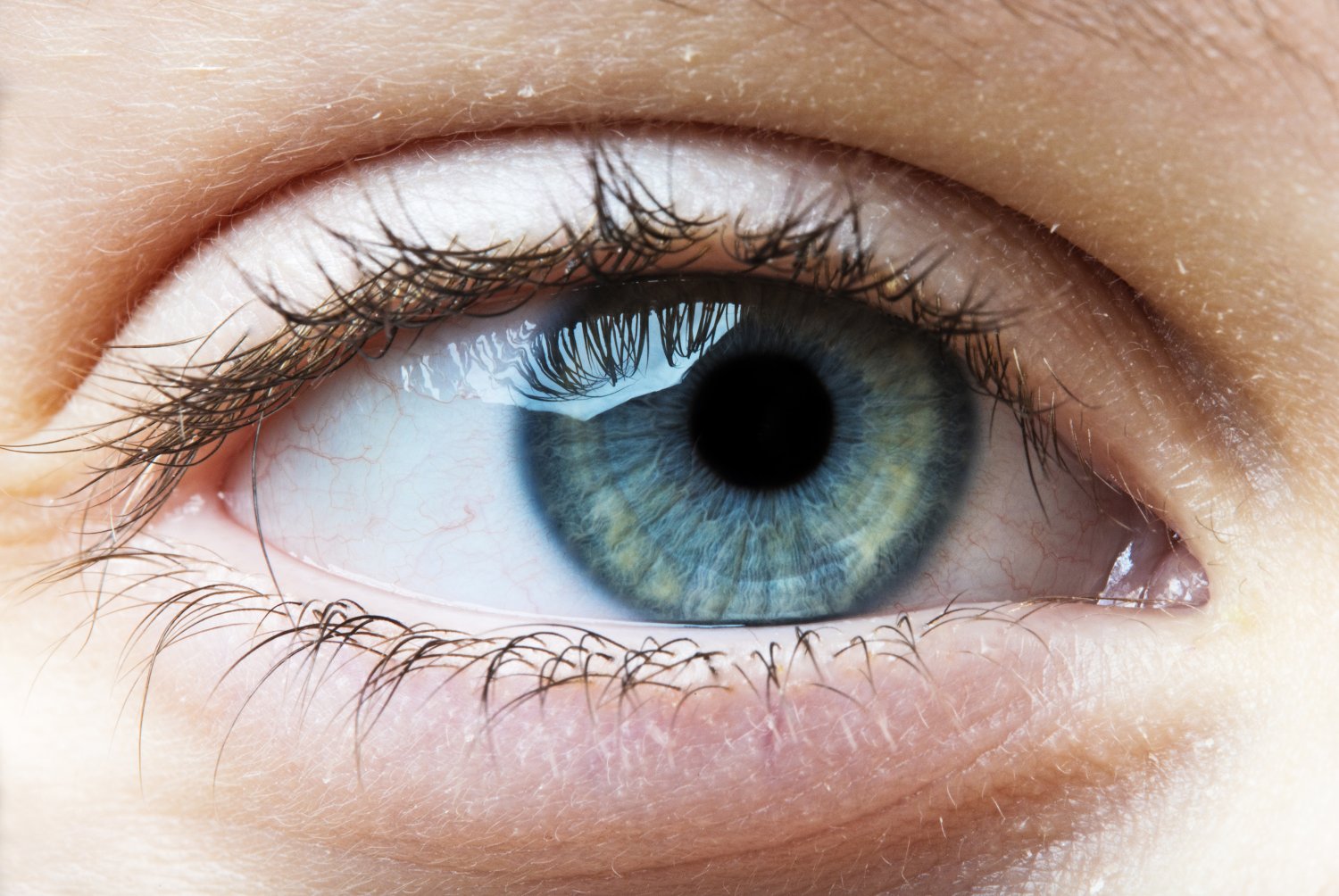 Oko kobiece z niebieską źrenicą i zaczerwienieniem wskazującym na możliwość zakażenie koronawirusem (covid-19).