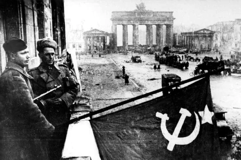 Żołnierze Armii Czerwonej wywieszają flagę Związku Radzieckiego na balkonie hotelu Adlon, w tle Brama Brandenburska, 1945.