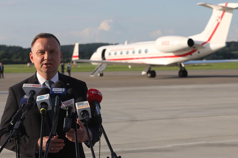 Andrzej Duda na konferencji prasowej na lotnisku, w tle samolot rządowy