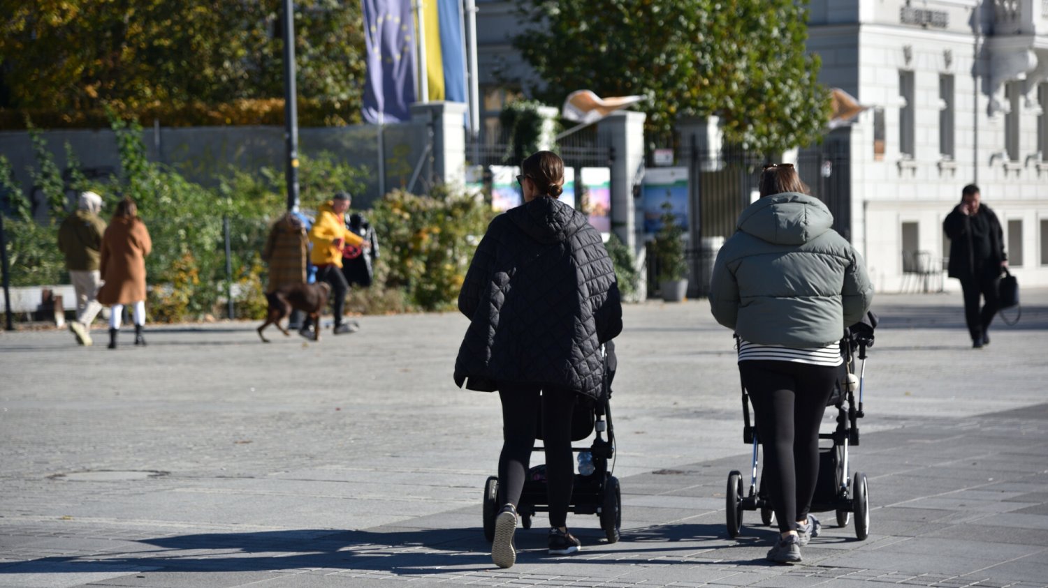 Prognozy pogody na wrzesień 2024. Jaki będzie początek jesieni w tym roku? Jesień w Europie Środkowej. Na zdjęciu widoczne dwie kobiety z wózkami dziecięcymi na ulicy obsypanej już spadającymi liśćmi.