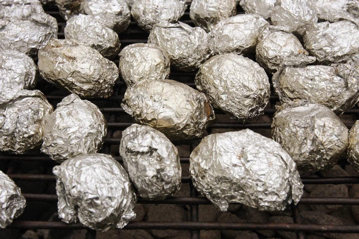 Ziemniaki w folii aluminiowej pieką się na ruszcie.