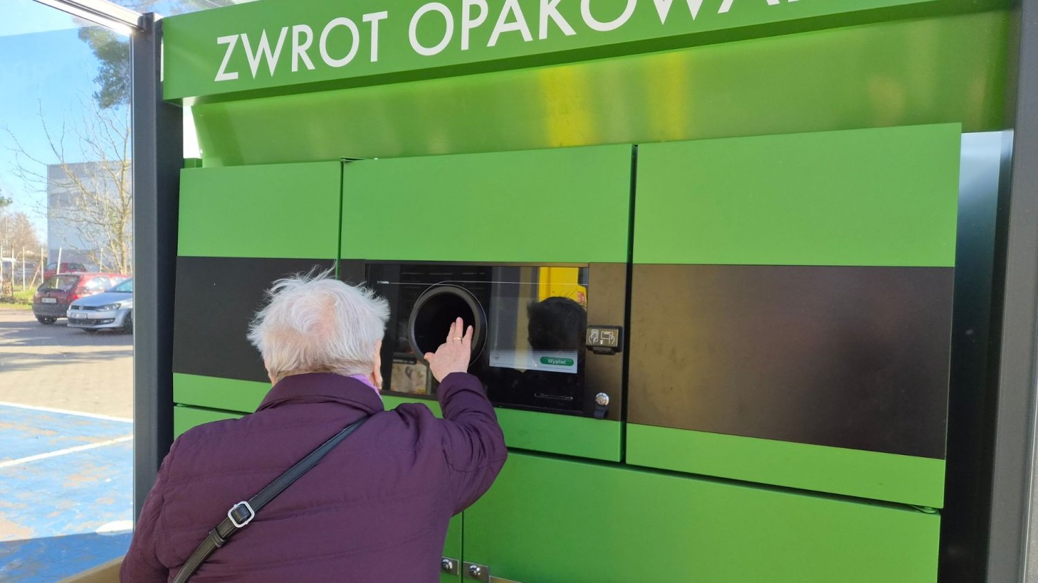 Kobieta wrzucające puste opakowanie do automatu na butelki z kaucją