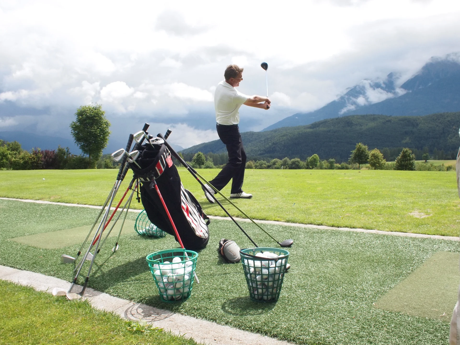 Na polu golfowym z widokiem na Alpy.