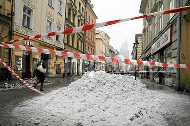 Kraków. Śnieg zrzucony z dachów zalegający na ulicy Floriańskiej.