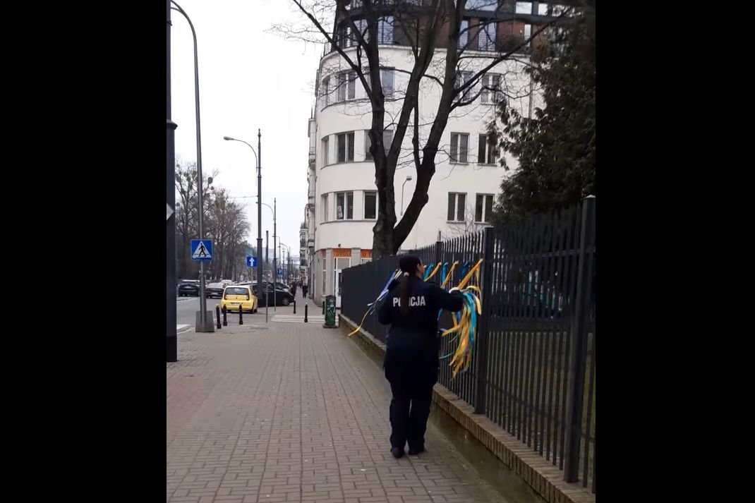 Policjantka zrywa symbole Ukrainy z rosyjskiej szkoły.