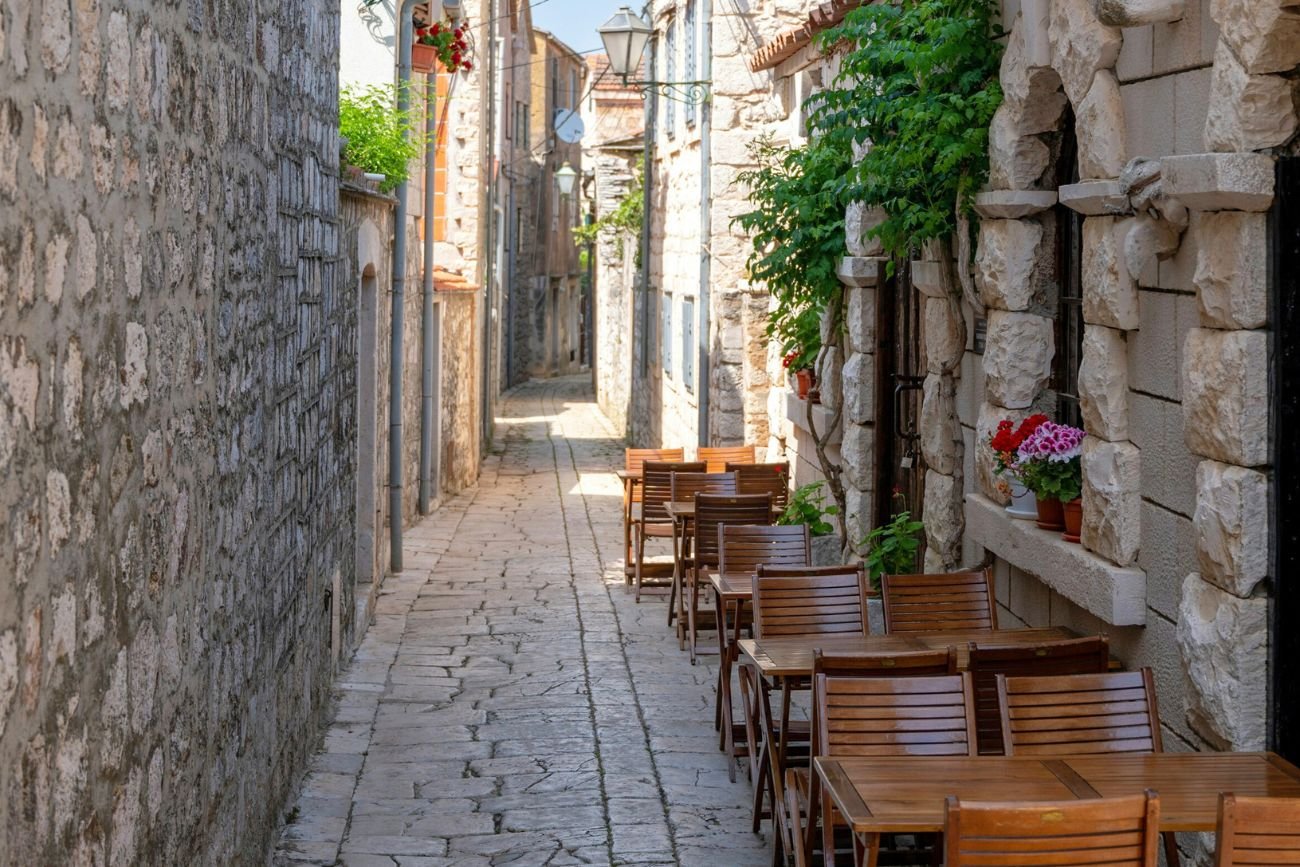 Uliczka w Chorwacji Uliczka w Chorwacji z restauracyjnymi stolikami