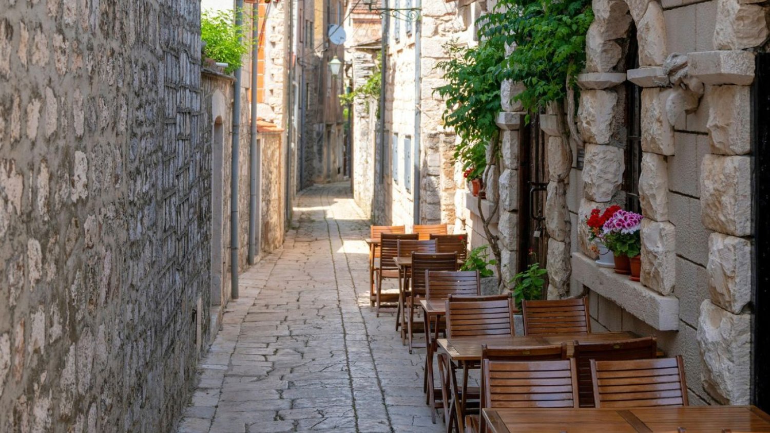 Uliczka w Chorwacji Uliczka w Chorwacji z restauracyjnymi stolikami
