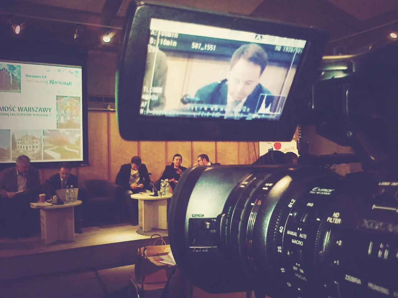 Debata „Tożsamość Warszawy - jaką Warszawę chcielibyśmy pokochać?”. W tle Prezydent Michał Olszewski.