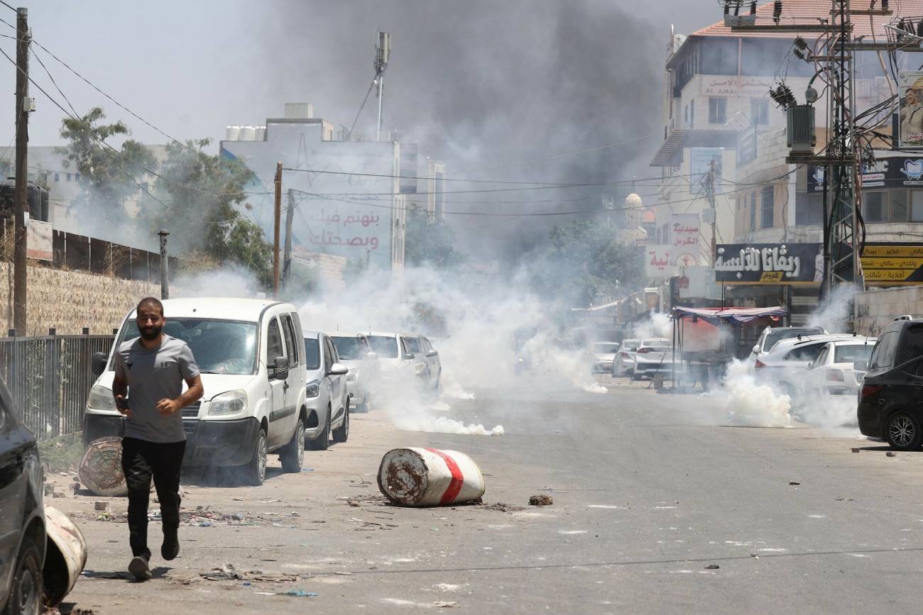 Mężczyzna ucieka z miejsca, w które trafił izraelski pocisk