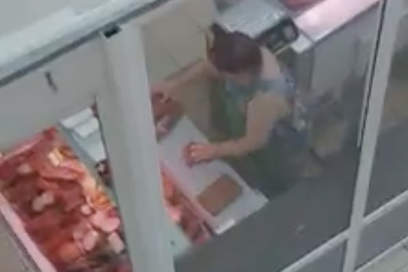 Kobieta w markecie w ukraińskich Czerniowcach wyciera mięso brudną szmatą.