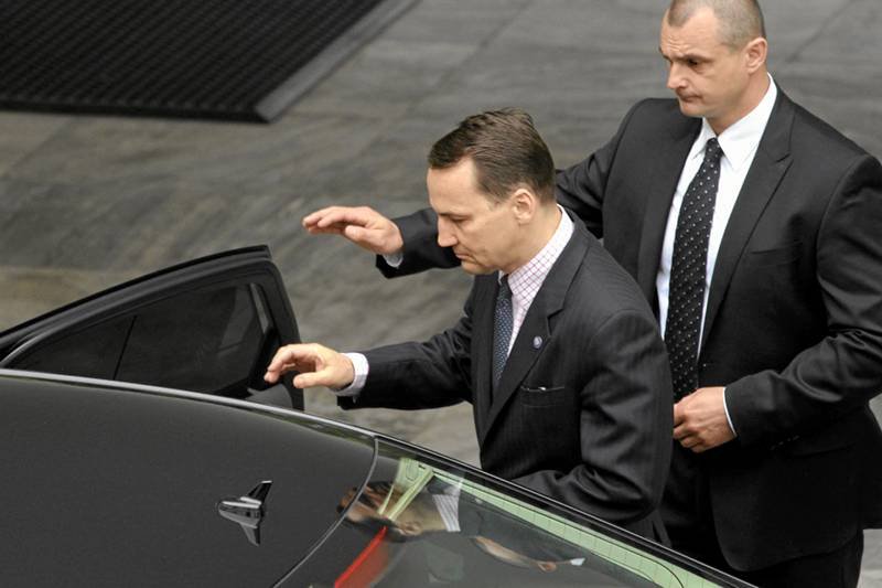 Radosław Sikorski wsiadający do służbowego samochodu.