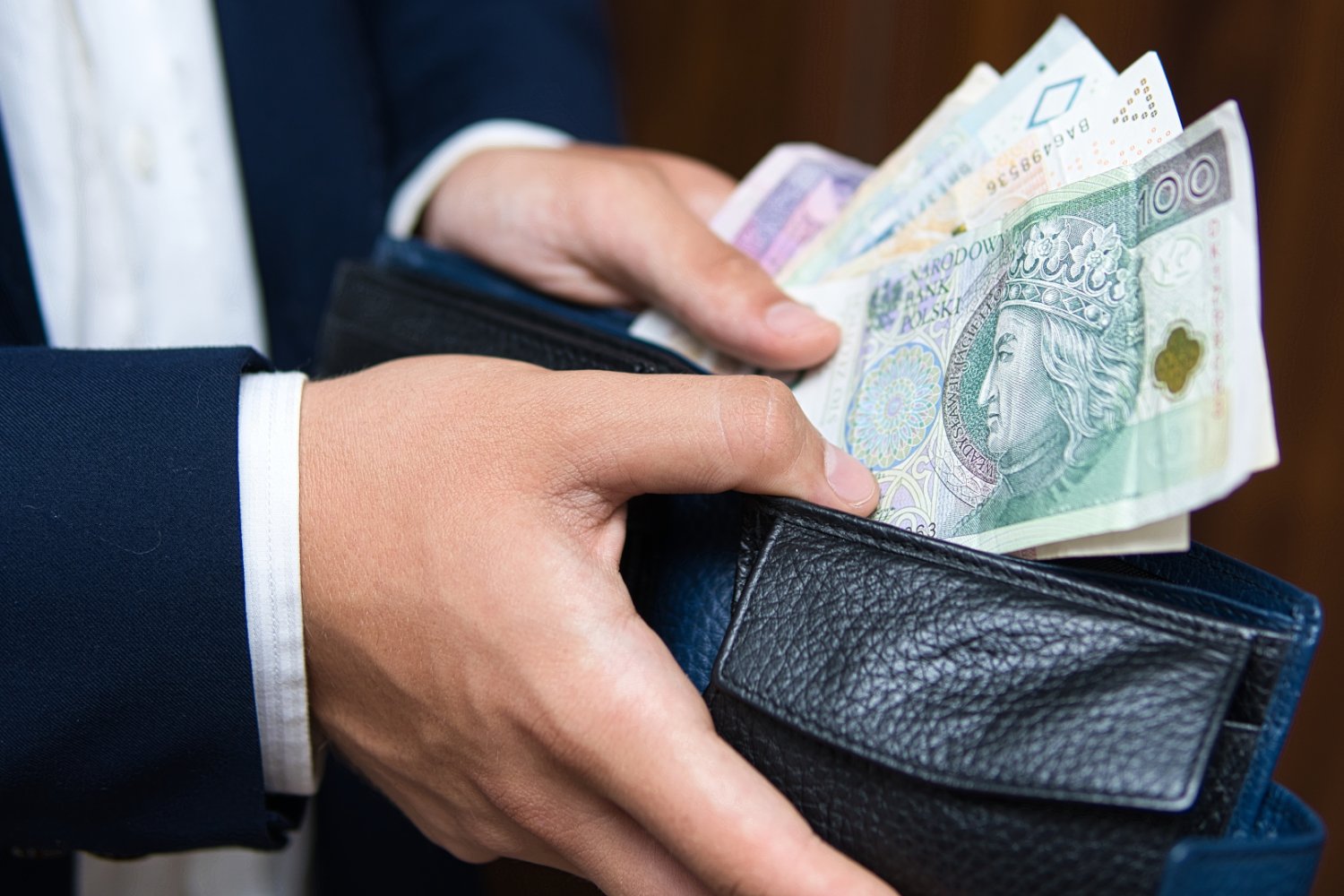Biznesmen wkładający pieniądze do portfela