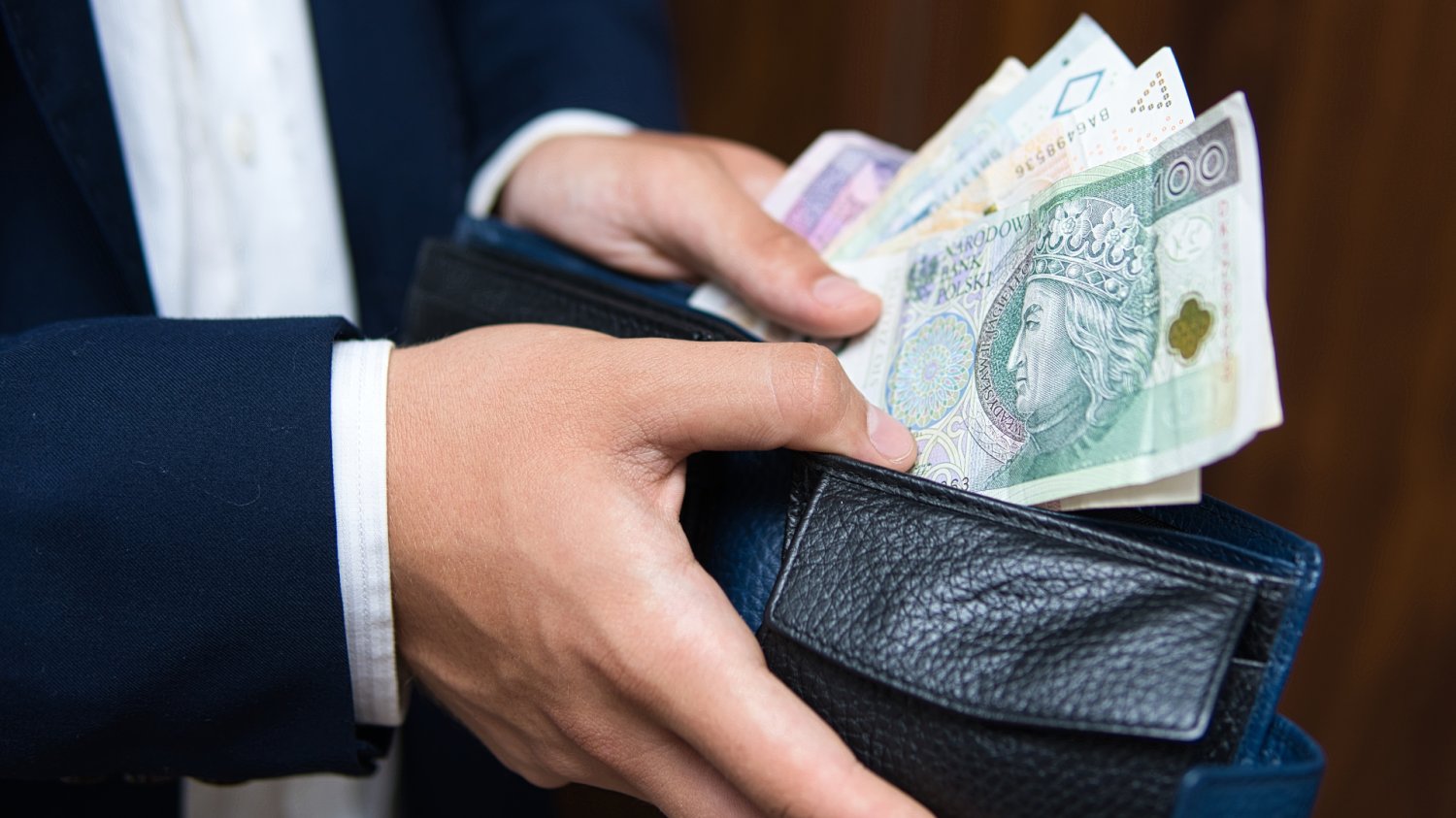 Biznesmen wkładający pieniądze do portfela