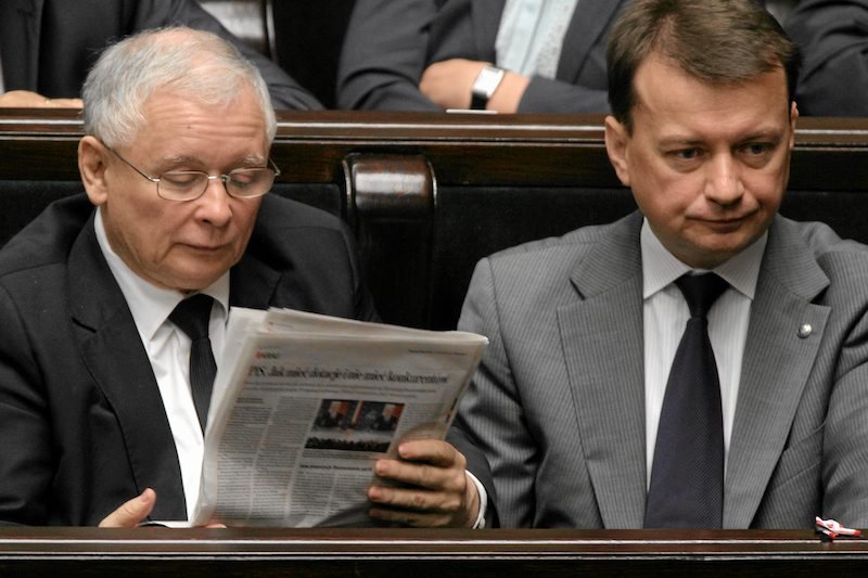 Jarosław Kaczyński, prezes PiS, w Sejmie podczas lektury "Gazety Wyborczej". Po prawej członek partii Mariusz Błaszczak (zdjęcie z 23 lipca 2013 roku).