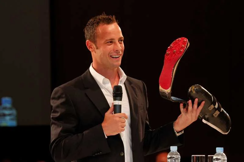 Oscar Pistorius biegacz bez nóg dumnie prezentuje swoją protezę.