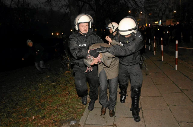 11 listopada 2010 roku. Policjanci prowadzą zatrzymanego Roberta Biedronia