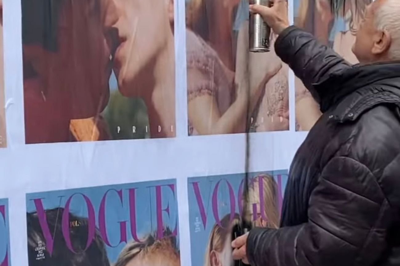 Starszy mężczyzna zamazuje na ulicach Warszawy plakaty z najnowszą okładką VOGUE poświęconą społeczności LGBT+