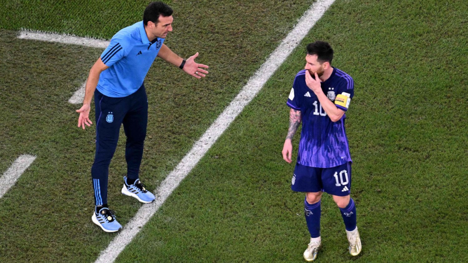 Trener Scaloni razem z Lionelem Messim dyskutują w trakcie drugiej połowy meczu z Polską o sytuacji w grupie C.