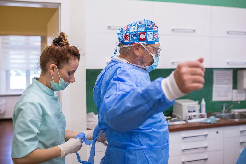 Lekarz i asystentka przygotowują się do wykonania zabiegu.