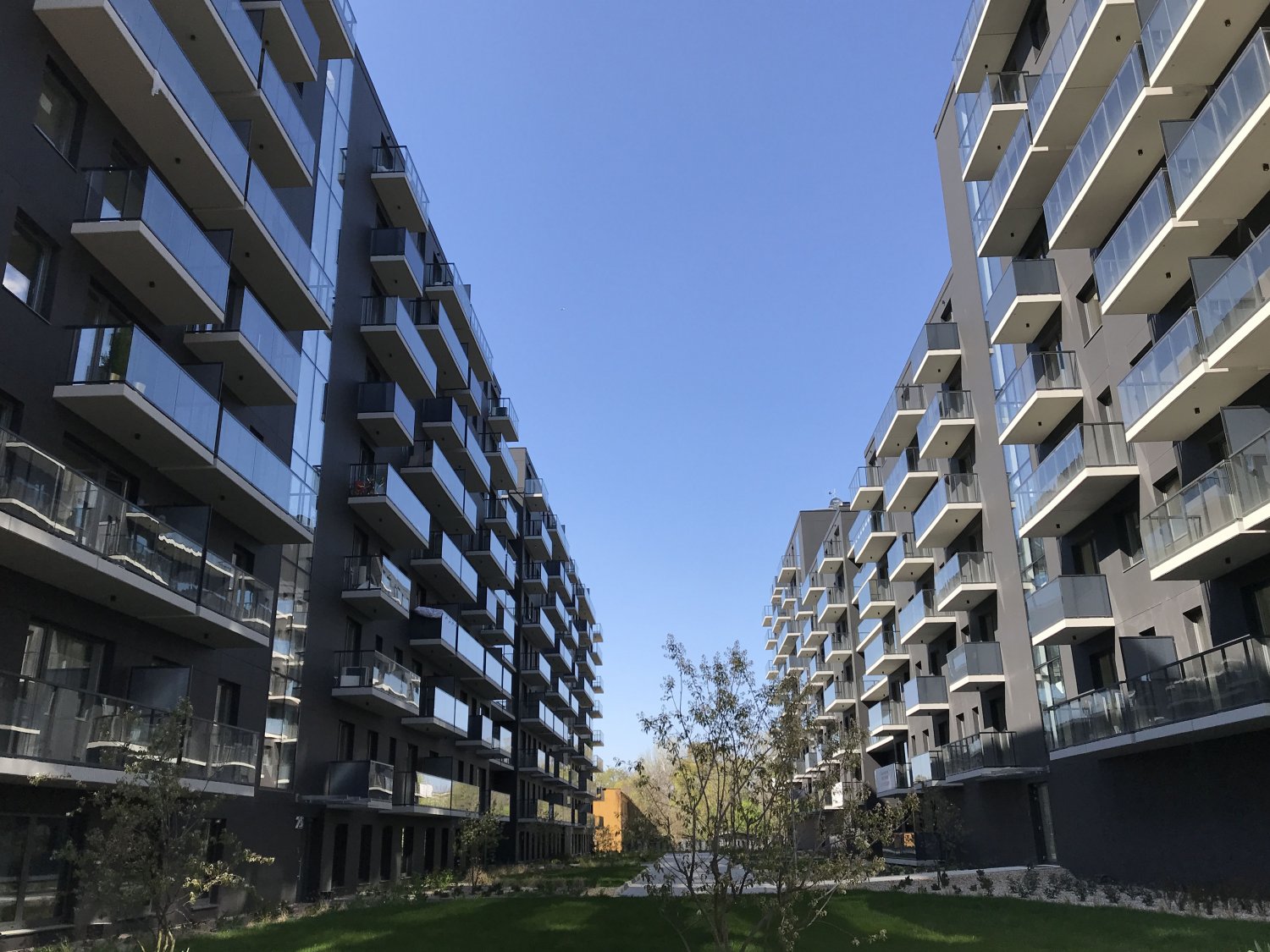 Nieprzyjazne wnętrze urbanistyczne współczesnej zabudowy. Głęboka, ciemna studnia i salon sąsiada za oknem.