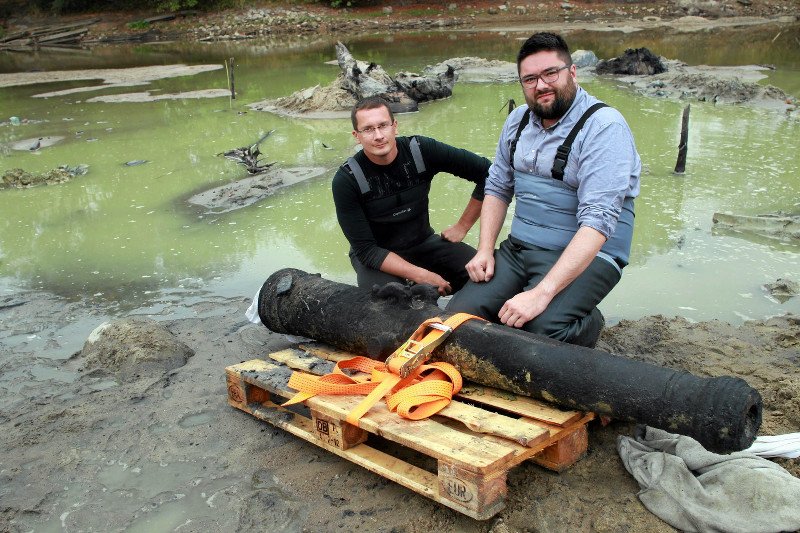 Jedna z luf armatnich wydobytych z Wisły. Od lewej archeolog Hubert Kowalski i wiceprezydent Warszawy Jarosław Jóźwiak.