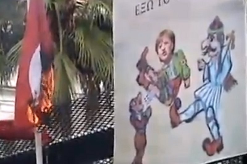 Takimi plakatami Grecy przywitali Angelę Merkel