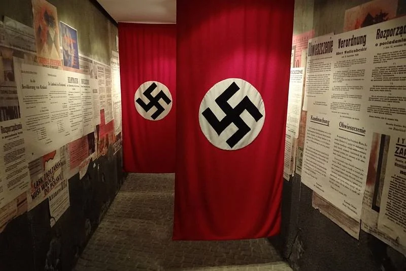 Pod tymi flagami stanowiącymi eksponaty muzealne w Fabryce Schindlera w Krakowie turyści potrafią robić sobie zabawne pamiątkowe zdjęcia.