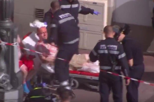 Służby z Marsylii opatrują rannych kibiców na ulicy.