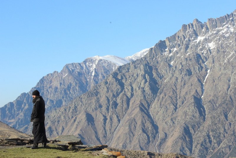 Prawosławny mnich, klasztor Cminda Sameba. W tle góry Kaukazu.