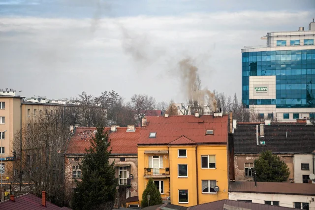 Ciemny dym wydostający się z komina domu w Krakowie