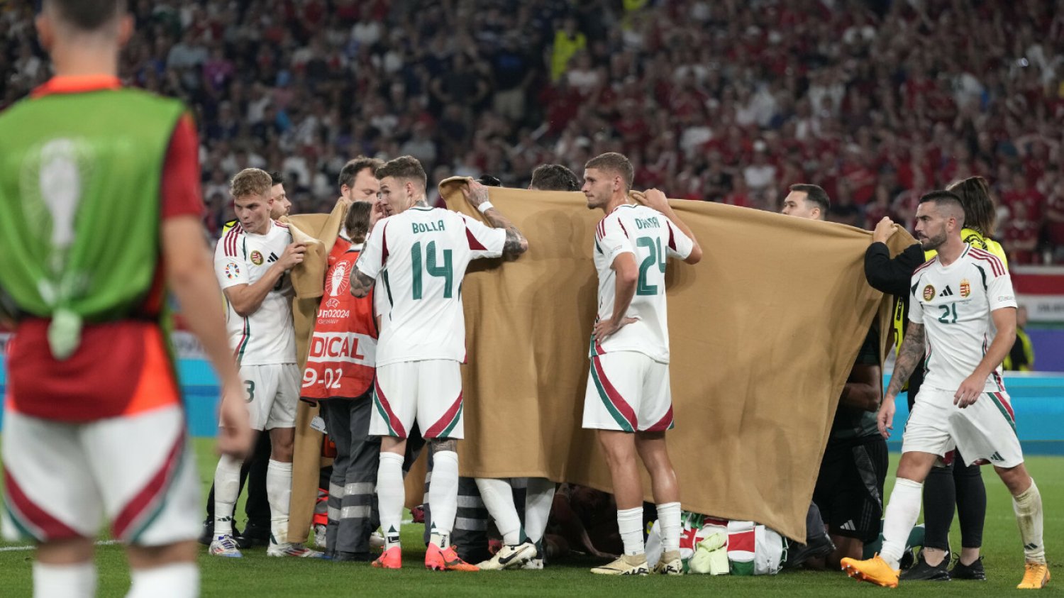 Węgierscy piłkarze pomagają zasłonić leżącego po zderzeniu z bramkarzem Barnabasa Vargę