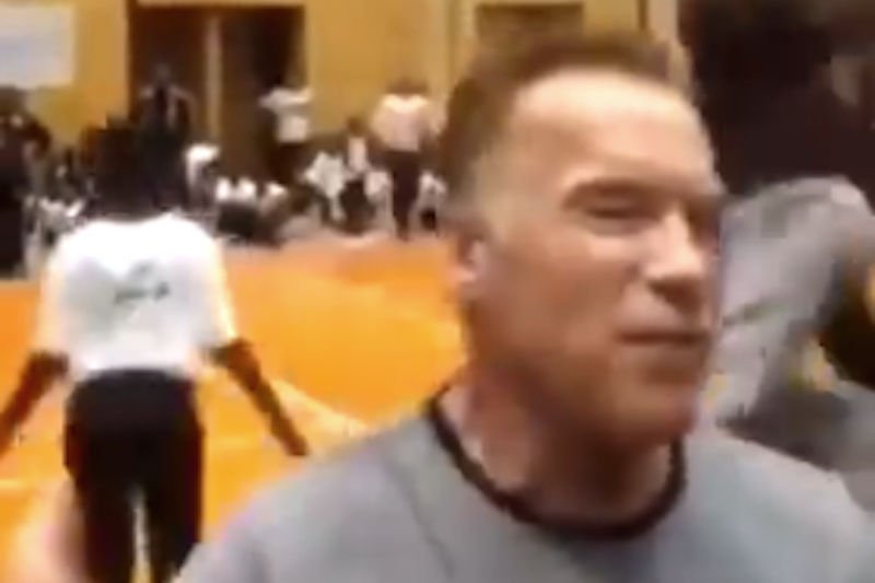 Arnold Schwarzenegger chwilę przed tym, jak został kopnięty w plecy.