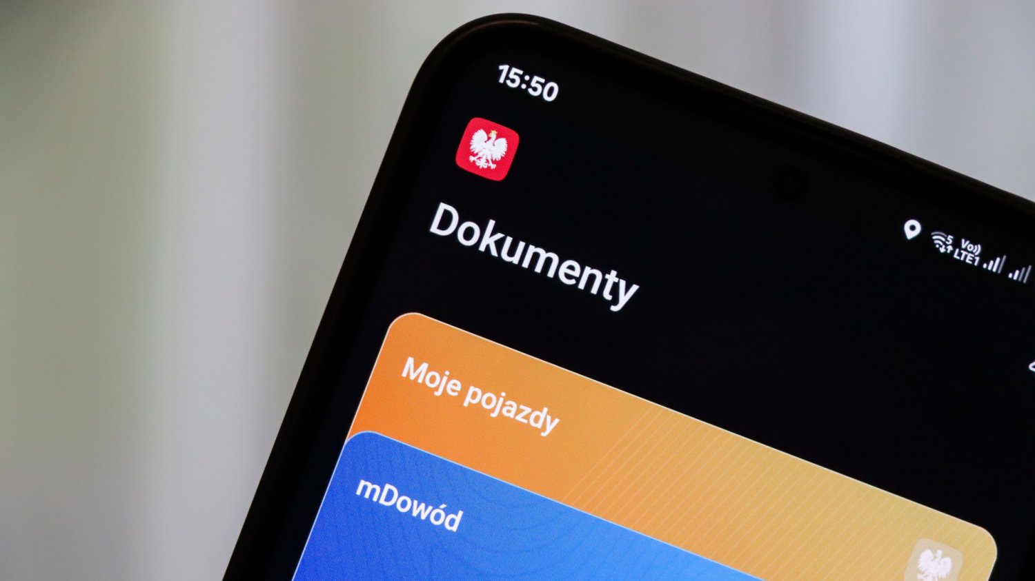Dłoń trzymająca smartfon z otwartą aplikacją mObywatel
